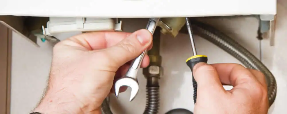 Boiler repair technician tightening pipe fittings and connections in Reno, NV