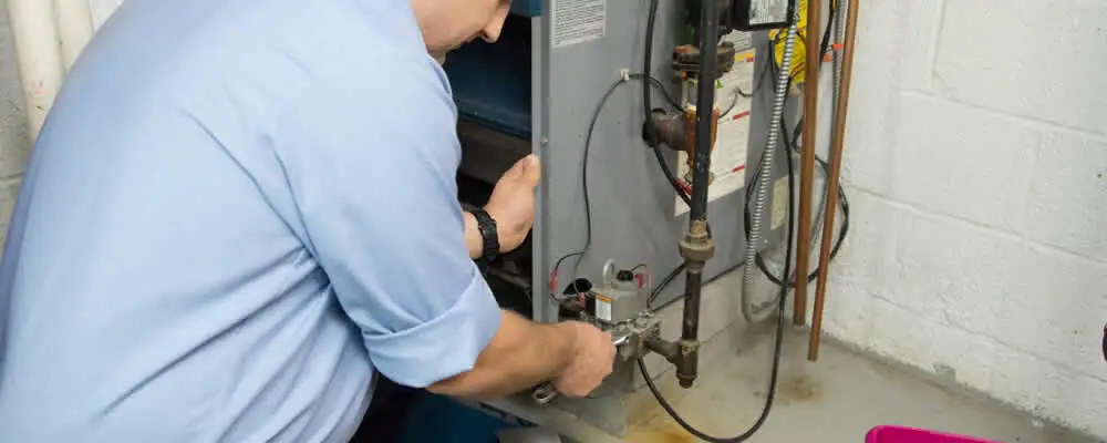 Furnace repair technician inspecting and servicing a home heating system in Reno, NV