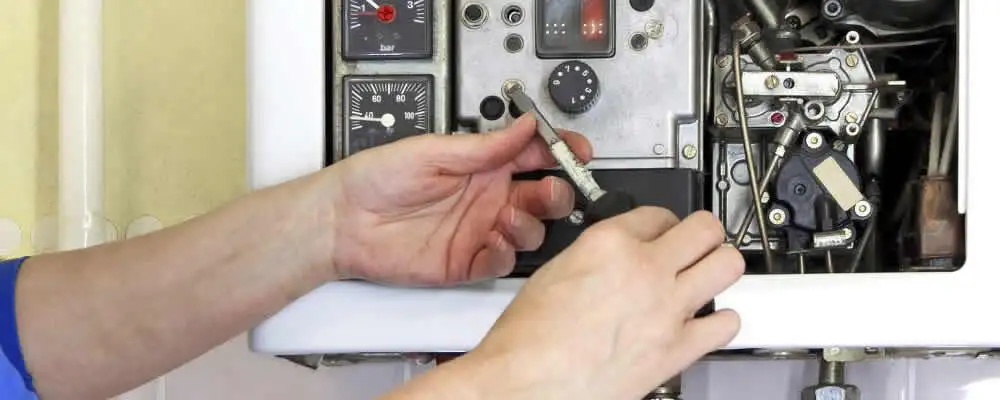 Heating repair technician adjusting boiler controls and components in Reno, NV