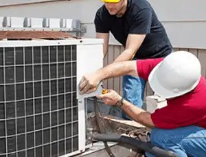 HVAC technicians repairing an outdoor AC unit on a rooftop in Reno, NV