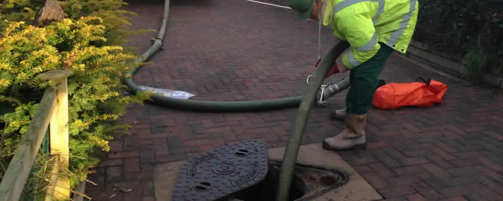 Septic tank cleaning technician servicing a septic tank with a vacuum hose in Reno, NV